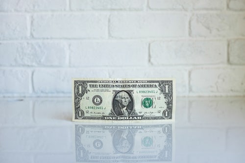 1 dollar bill against a backspash