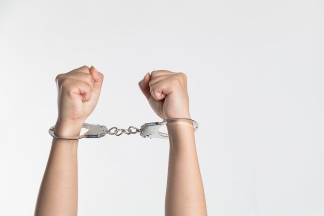 angry fists in the air with handcuffs on
